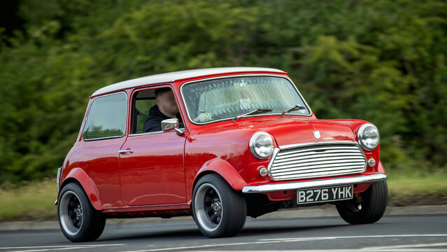 Stony Stratford,Bucks,UK - June 7th 2026:  1985 red Rover Mini  car driving on a British road