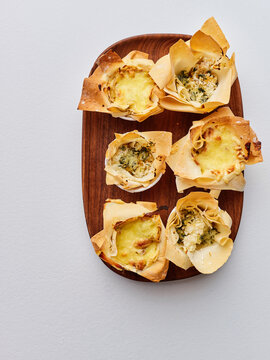 Savory cheese and vegetable pastries in crispy phyllo cups, gourmet appetizer platter for entertaining guests