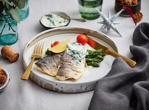 Grilled fish fillet with creamy sauce, asparagus, and cherry tomatoes, upscale dining menu inspiration