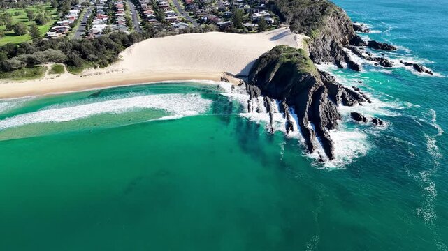 Aerial video panning around Bennetts Headland and the prominent sand dune at One Mile Beach near Forster, NSW, Australia