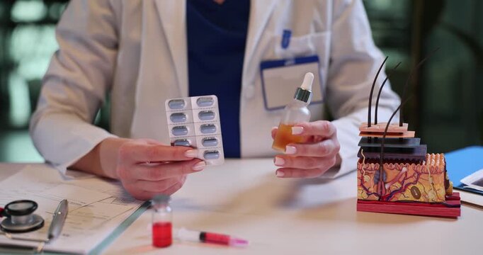 Female dermatologist holds serum bottle and pills blister near skin layers model at desk. Doctor recommends pharmacy products for skincare in clinic