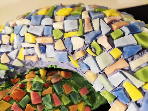 Close-up of a colorful mosaic made of ceramic fragments. Abstract texture, decorative art, handmade craftsmanship, detailed mosaic pattern.