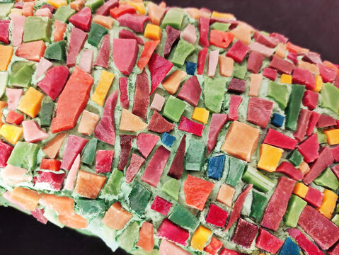 Close-up of a colorful mosaic made of ceramic fragments. Abstract texture, decorative art, handmade craftsmanship, detailed mosaic pattern.