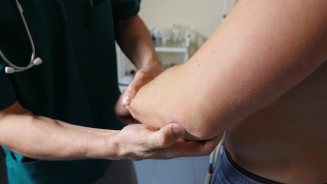 Medical professional examining patient's elbow joint, demonstrating careful manipulation and assessment of movement, showcasing the importance of thorough physical examination in healthcare settings