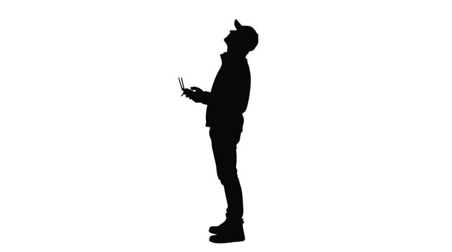 Silhouette of a man operating a drone controller looking up