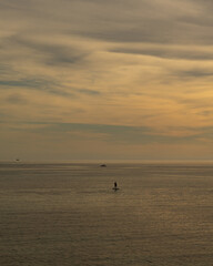 Lone paddleboarder on a calm golden sea at sunset under a vast sky, Mediterranean, Mallorca © Ricardo