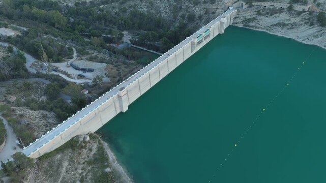 High angle aerial view of a concrete water dam reservoir