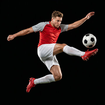 Dynamic Soccer Player Jumping and Kicking Ball in Mid Air Isolated on Black Background