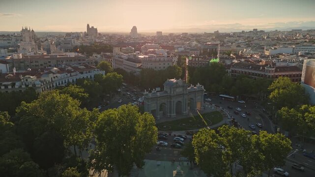 Aerial tracking shot moving towards and around the Puerta de Alcala arch
