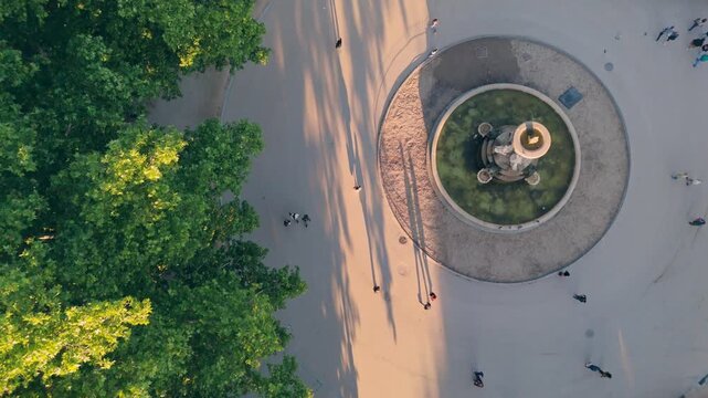 Zenital drone shot of park fountain at sunset