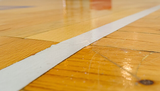 A white boundary line cuts the varnished court like a quiet portal into the next play