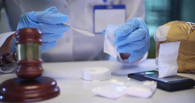 Woman forensic scientist pours white powder into plastic bag on digital scales in lab. Expert fills package with drugs in criminal laboratory