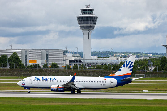 Ein Boeing 737-800 der SunExpress (TC-SPH) rollt auf dem Vorfeld des Flughafens M&uuml;nchen. Im Hintergrund ist der charakteristische Tower des Flughafens zu sehen.