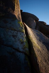 Fototapeta premium Rugged Mountain Rock Formation with Lichen and Clear Blue Sky at Sunset