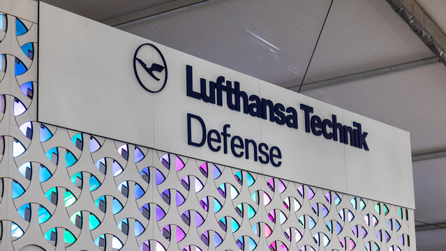Logoschild von Lufthansa Technik Defense an einem beleuchteten Messestand 