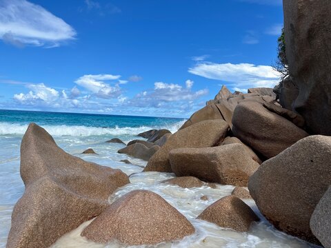 The beautiful Grand Ance Beach on La Digue Island in the Seychelles. Turquoise sea, waves, huge cliffs, white sand