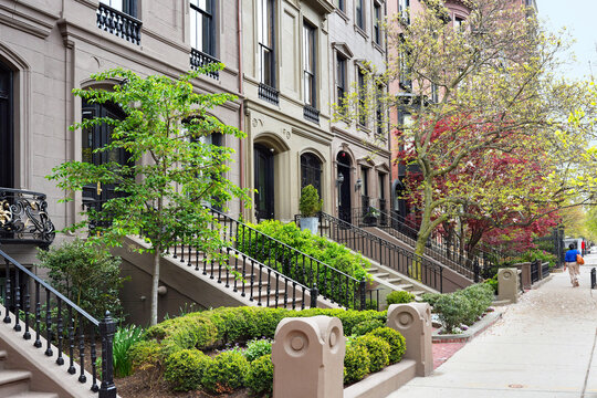Street with row of old brownstone style townhouses or apartment buildings