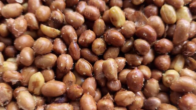 Close-up of crispy roasted peanuts with salt sprinkles