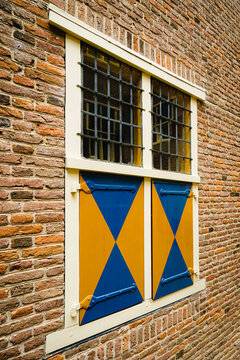 Dim light filters through barred windows onto weathered brick walls.