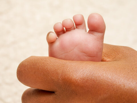 Pied de nouveau-n&eacute; reposant dans la main d&rsquo;un parent, symbole de protection et de tendresse