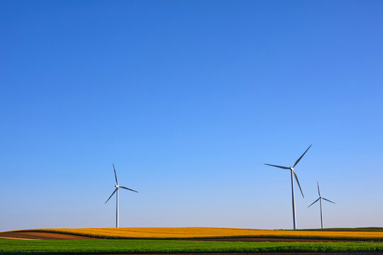 Wind turbines at sunset in green field &ndash; renewable energy, clean power, sustainable future.