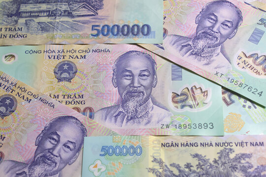 Vietnamese banknotes of 500 thousand dong (VND) with portrait of Ho Chi Minh laying on the table surface. Close-up view.