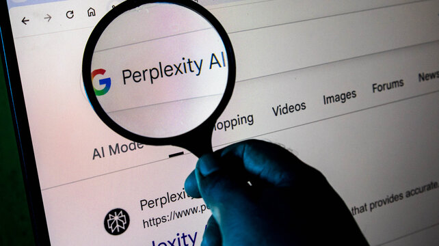 A person holding a magnifying glass over a computer screen displaying a google search result for perplexity ai