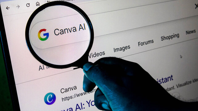 A person using a magnifying glass to search for canva ai on a computer screen, highlighting the intersection of technology and design
