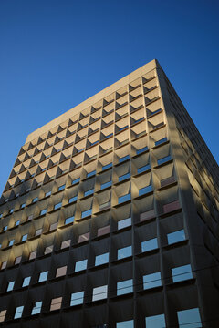 Building with windows and shadows under blue sky at evening
