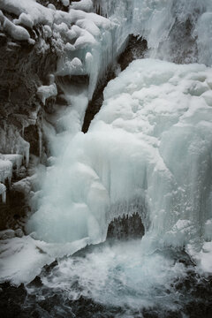 Frozen waterfall in winter with icy rocks and flowing water