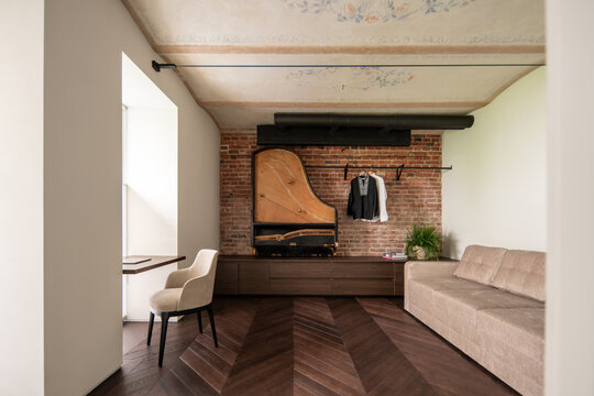 Living room with exposed brick wall and vintage piano