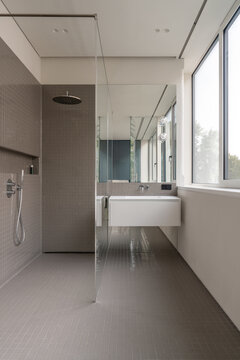 Minimal bathroom with glass partition and large window