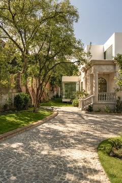 Driveway leading to renovated house with garden