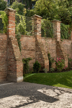 Brick garden wall with greenery and sunlight