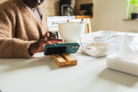 Close up of African Woman Following Baking Recipe on Smartphone