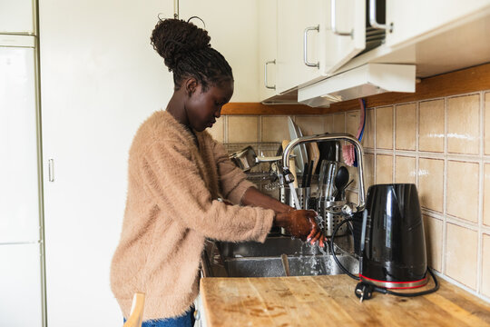 Young Woman Washing Hands at Kitchen Sink Before Cooking
