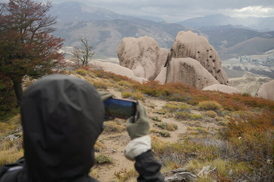 Person Takes a Picture of Rock Formations in a Mountainous Area