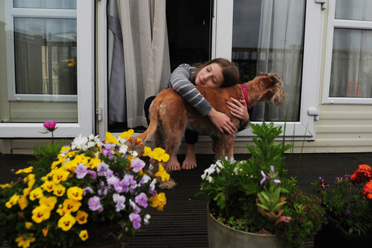 People and Pets - a girl and her dog sit on the doorstep