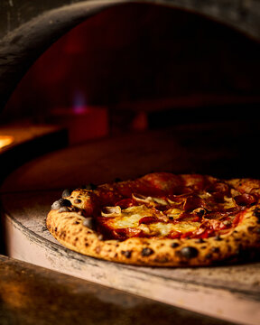 Artisan Pepperoni Pizza Baking In Traditional Wood Fired Oven. 