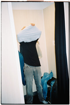 a man tries on clothes in a fitting room, 35mm film