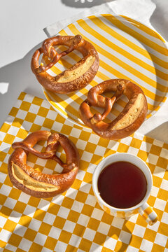 Freshly Baked Pretzels and Tea on a Checkered Tablecloth 