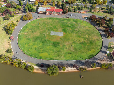 Green sports oval surrounded by a road and  a grandstand