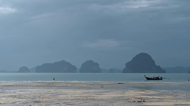 Lone visitor walking beside Tubkaek Beach boat