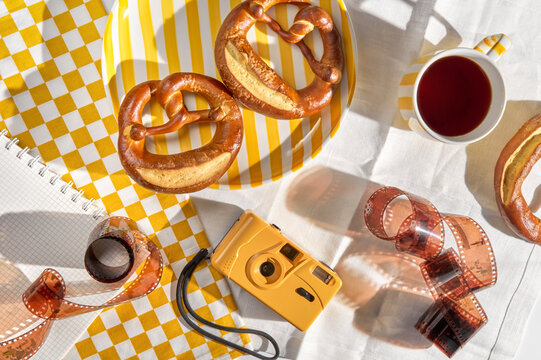 Freshly Baked Pretzels on a Table With a Cup of Tea and a Camera