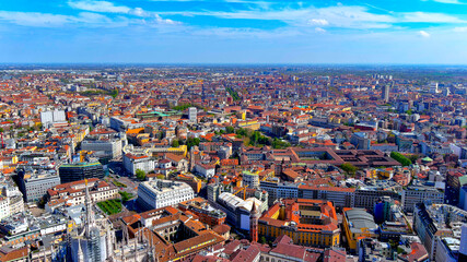 Obraz premium Aerial drone view of Milan city center urban landscape with historical buildings and the spires of the Duomo di Milano on a sunny day in Lombardy Italy.