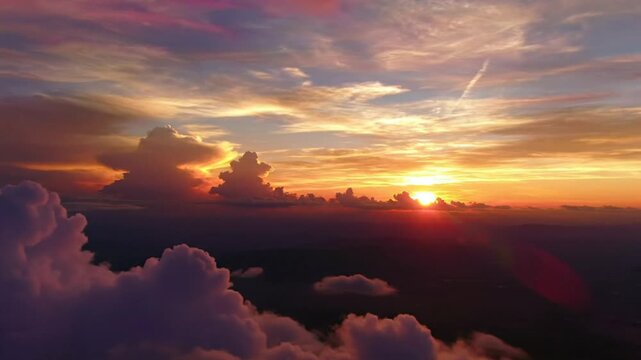 Breathtaking aerial view of a vibrant sunset over the cloudscape with a radiant sun ablaze above the horizon