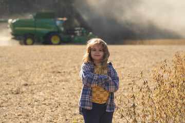 Fototapeta premium Child in a wheat field. Little farmer at farm field. Kid at rural countryside. Carefree childhood outdoors. Kid in golden wheat field. Kid in meadow. Harvest season. Rural field, child on farmland.