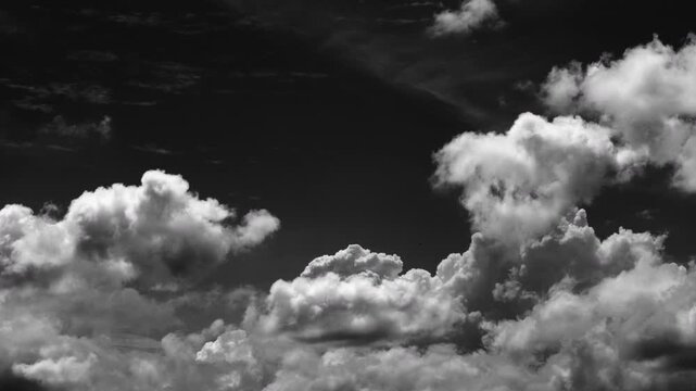 Time-lapse of white clouds drift quickly against a pure black background