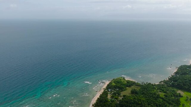 Blue sea with waves and corals. Paddy fields in Santa Fe, Tablas, Romblon, Philippines.