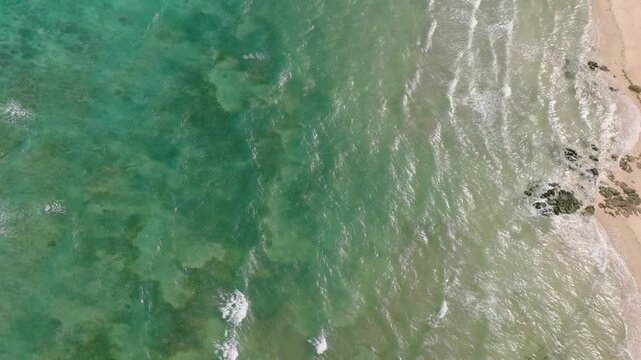 Aerial view of sea waves and sandy beach with sun reflection. Santa Fe, Tablas, Romblon. Philippines.